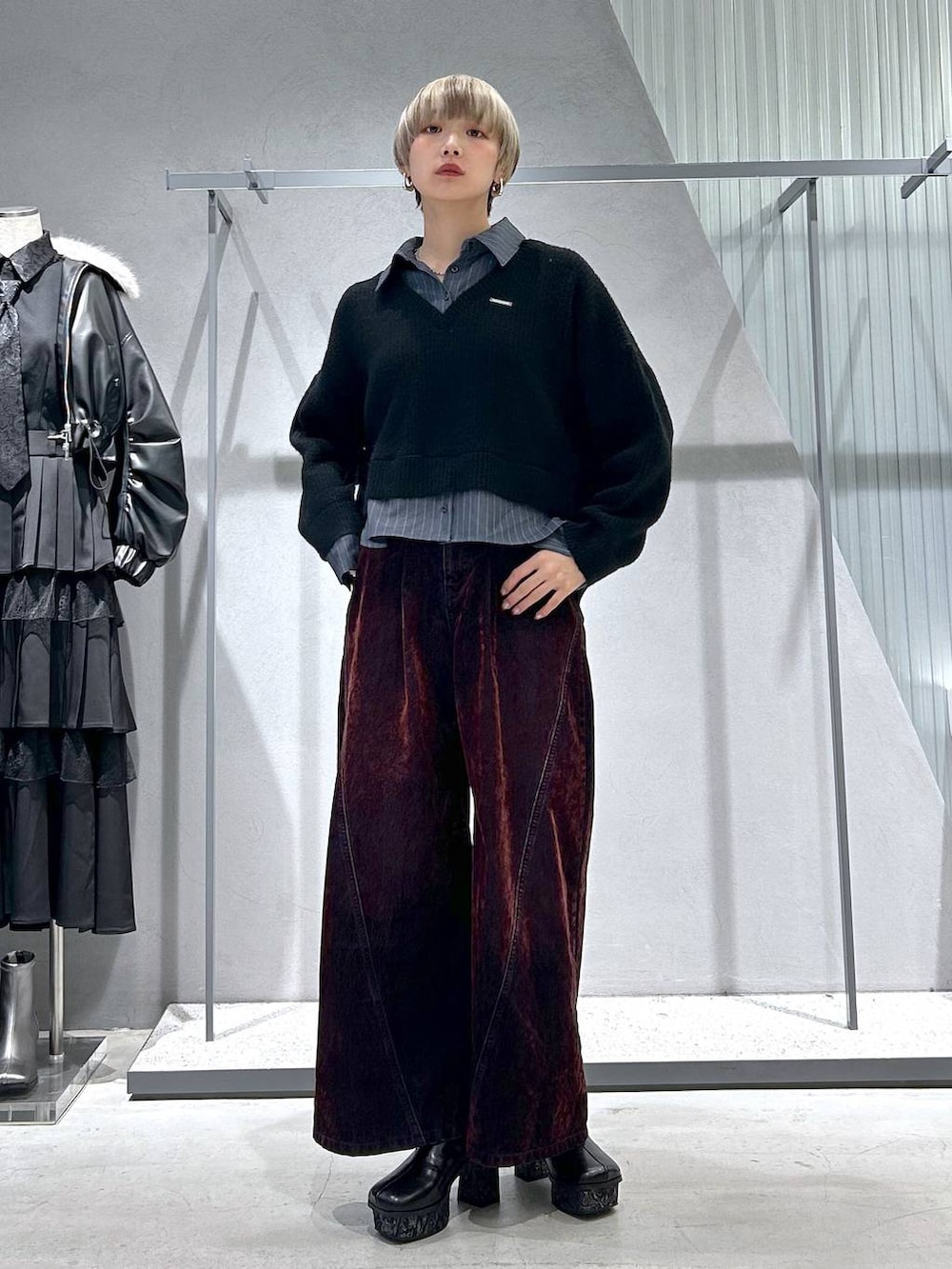 グレー系のブーツ、ブラック系のニット/セーター、レッド系のデニムパンツを着用したレディースの冬コーディネートの2枚目の写真