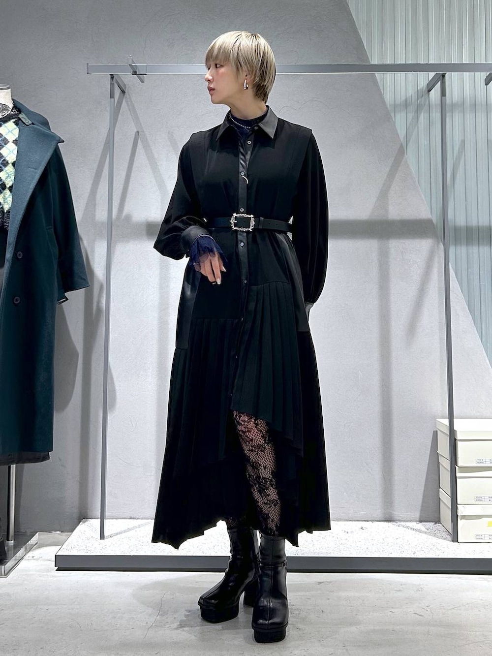 ブラック系のチェスターコート、パープル系のTシャツ/カットソー、グレー系のブーツを着用したレディースの冬コーディネートの7枚目の写真