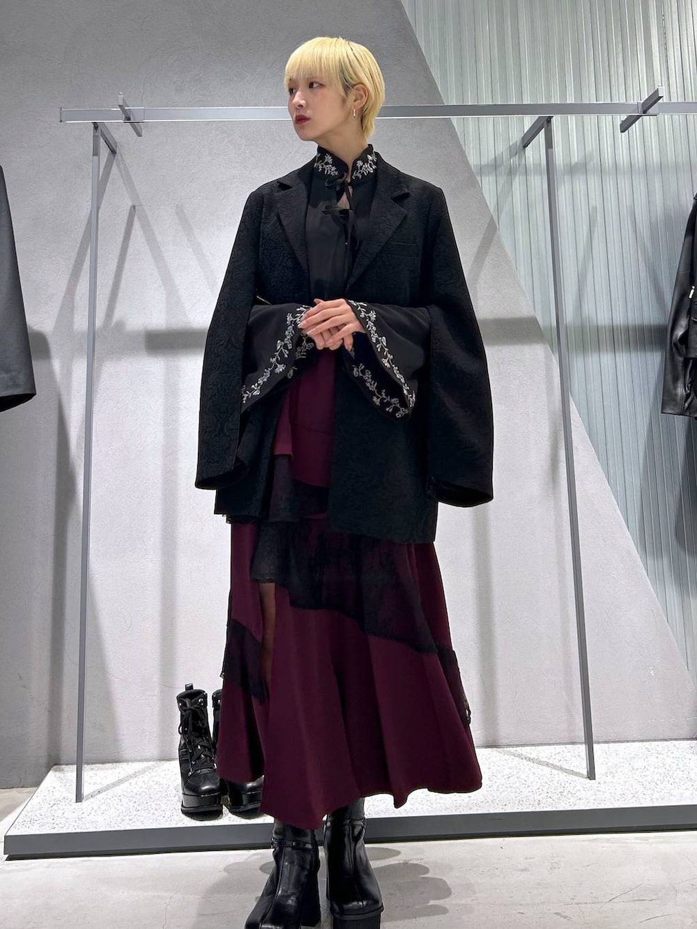 グレー系のブーツ、ブラック系のテーラードジャケット、ブラック系のシャツ/ブラウスを着用したレディースの秋コーディネートの3枚目の写真