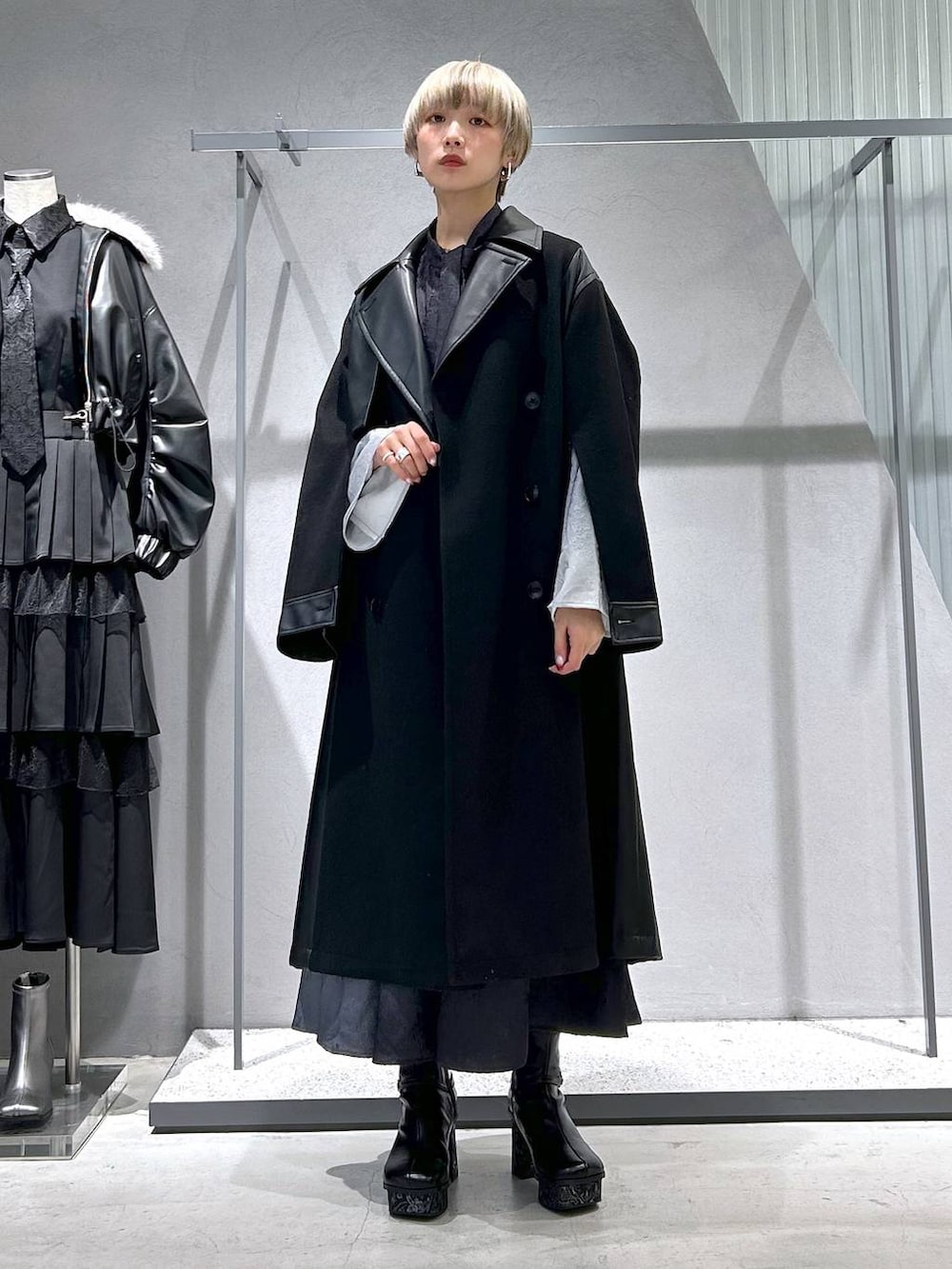 ブラック系のチェスターコート、グレー系のブーツ、ブラック系のシャツ/ブラウスを着用したレディースの冬コーディネートの3枚目の写真