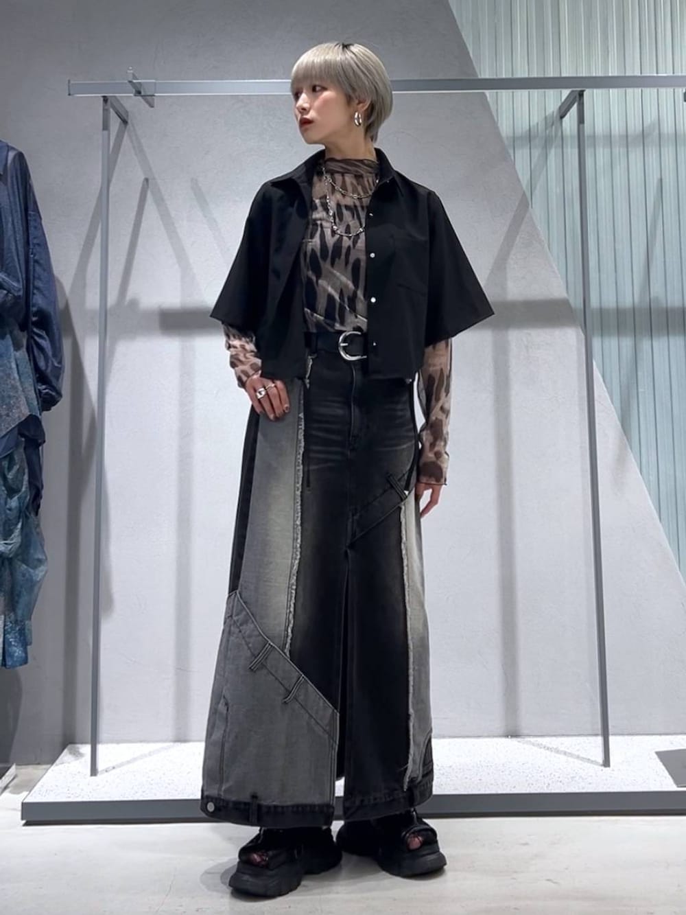 ブラック系のサンダル、ブラック系のデニムスカート、ブラック系のシャツ/ブラウスを着用したレディースの夏コーディネートの2枚目の写真