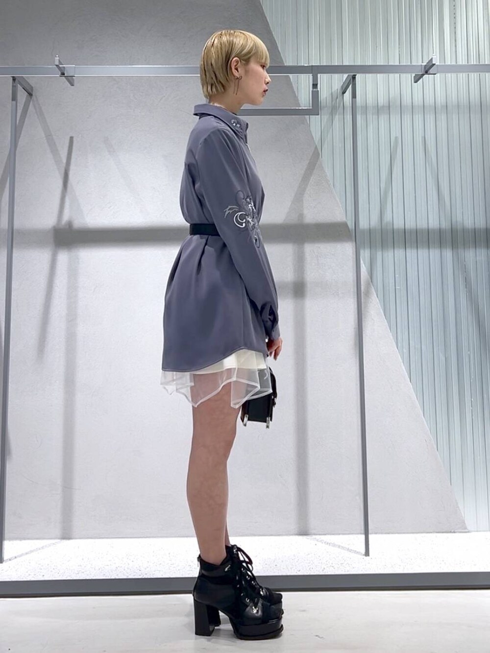 ブラック系のショルダーバッグ、パープル系のシャツ/ブラウス、ブラック系のブーツを着用したレディースの春コーディネートの5枚目の写真