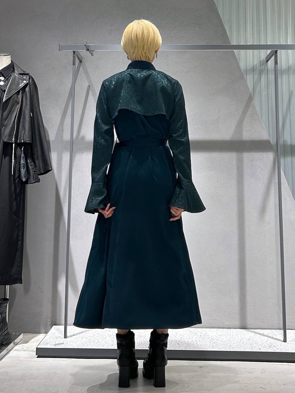 ブラック系のブーツ、グリーン系のワンピースを着用したレディースの秋コーディネートの3枚目の写真