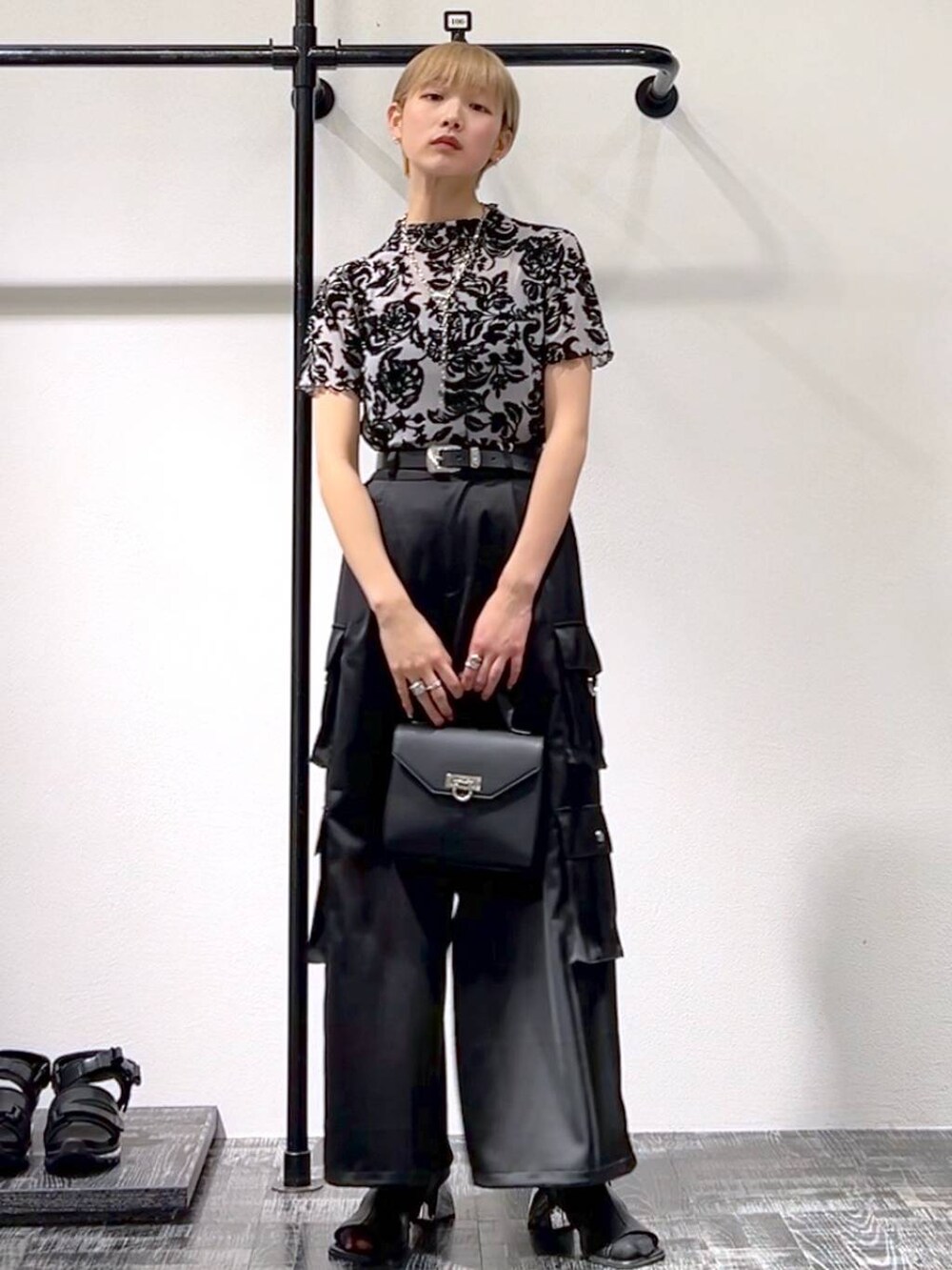 ブラック系のカーゴパンツ、ブラック系のショルダーバッグ、ブラック系のサンダルを着用したレディースの春コーディネートの3枚目の写真