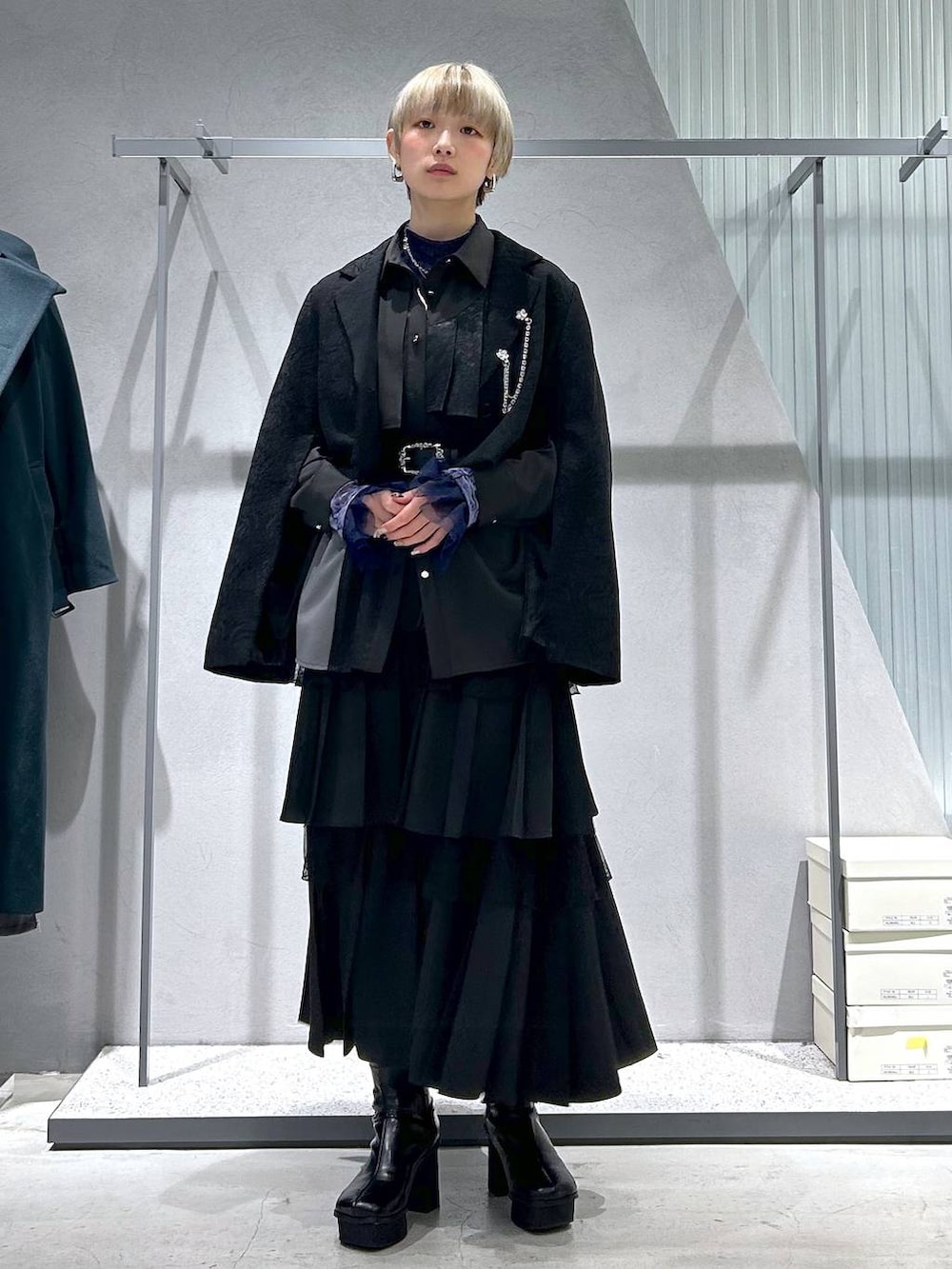 パープル系のTシャツ/カットソー、グレー系のブーツ、ブラック系のテーラードジャケットを着用したレディースの冬コーディネートの4枚目の写真