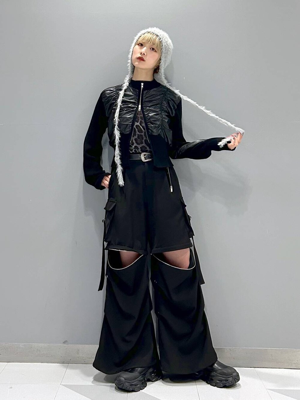 グレー系のTシャツ/カットソー、ブラック系のカーゴパンツ、ブラック系のブーツを着用したレディースの冬コーディネートの4枚目の写真