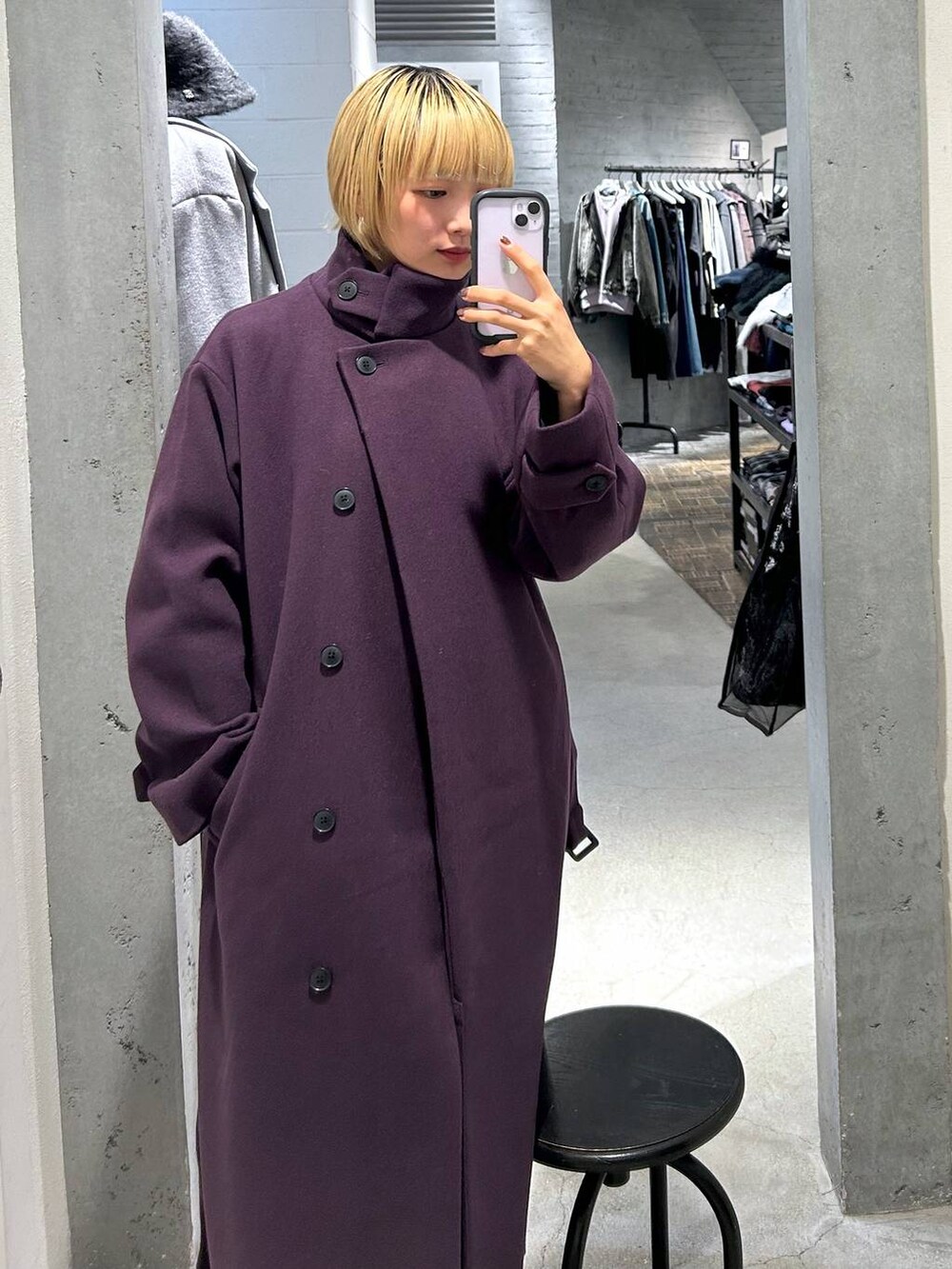 パープル系のチェスターコートを着用したレディースの秋コーディネートの2枚目の写真