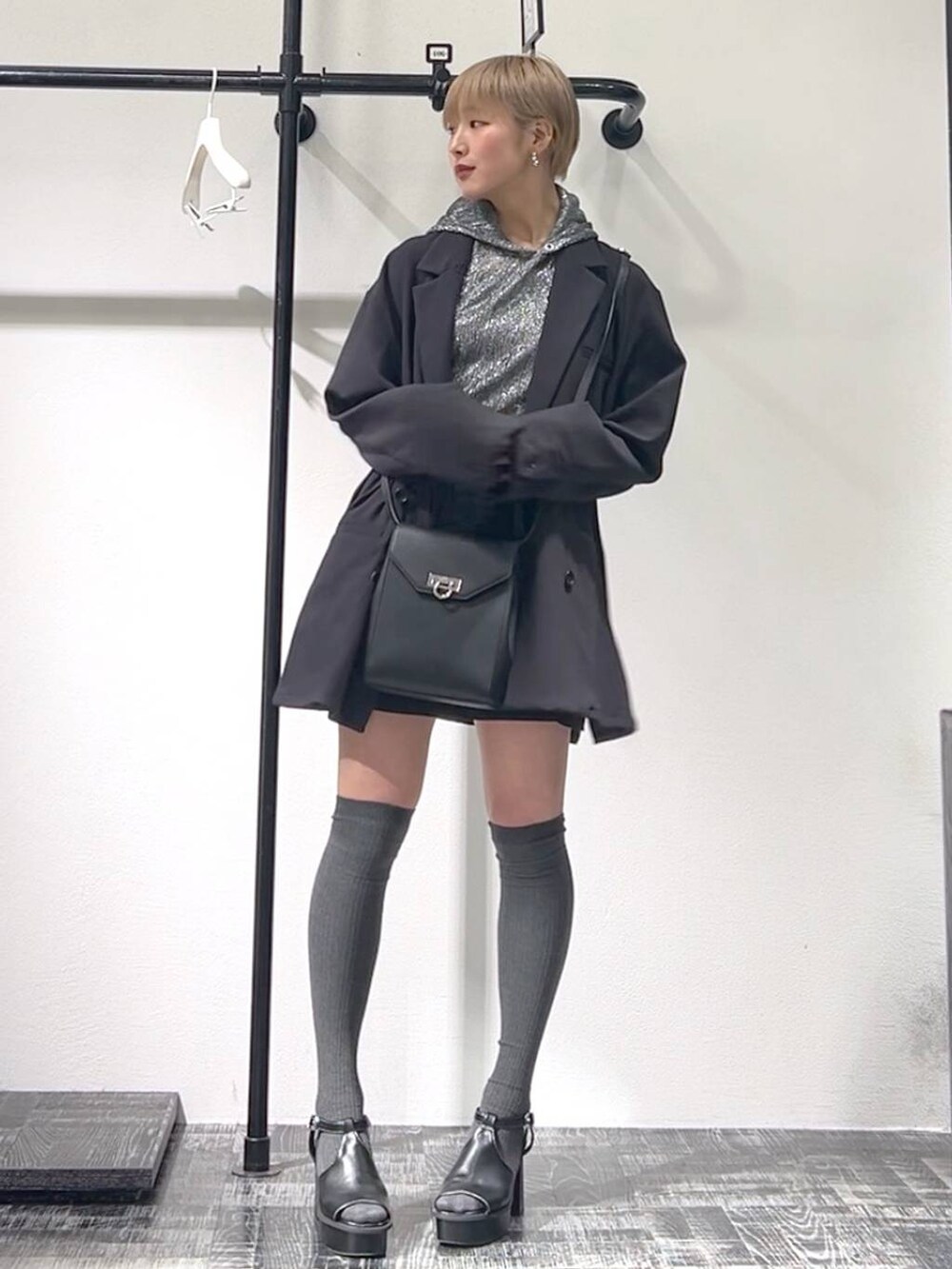 ブラック系のサンダル、ブラック系のショルダーバッグ、ブラック系のパーカーを着用したレディースの春コーディネートの3枚目の写真