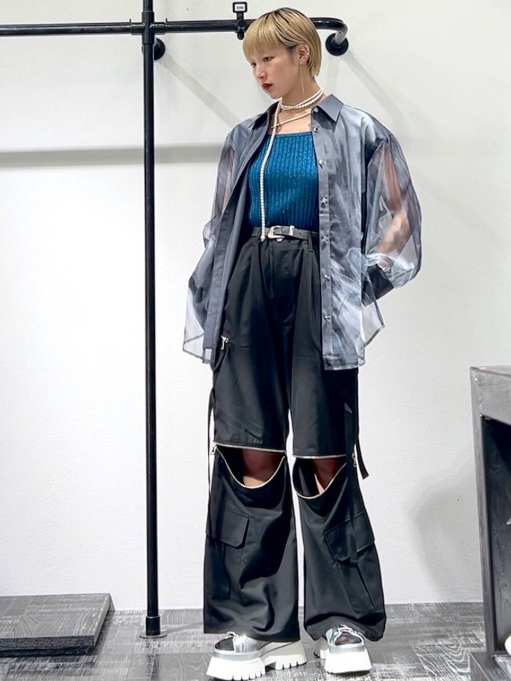 シルバー系のサンダル、ブルー系のタンクトップ、ブラック系のカーゴパンツを着用したレディースの春コーディネートの3枚目の写真