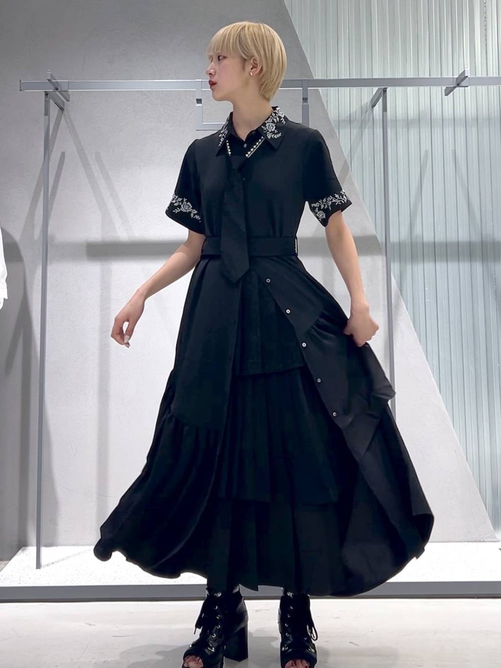 ブラック系のネクタイ、ブラック系のブーツ、ブラック系のスカートを着用したレディースの春コーディネートの5枚目の写真