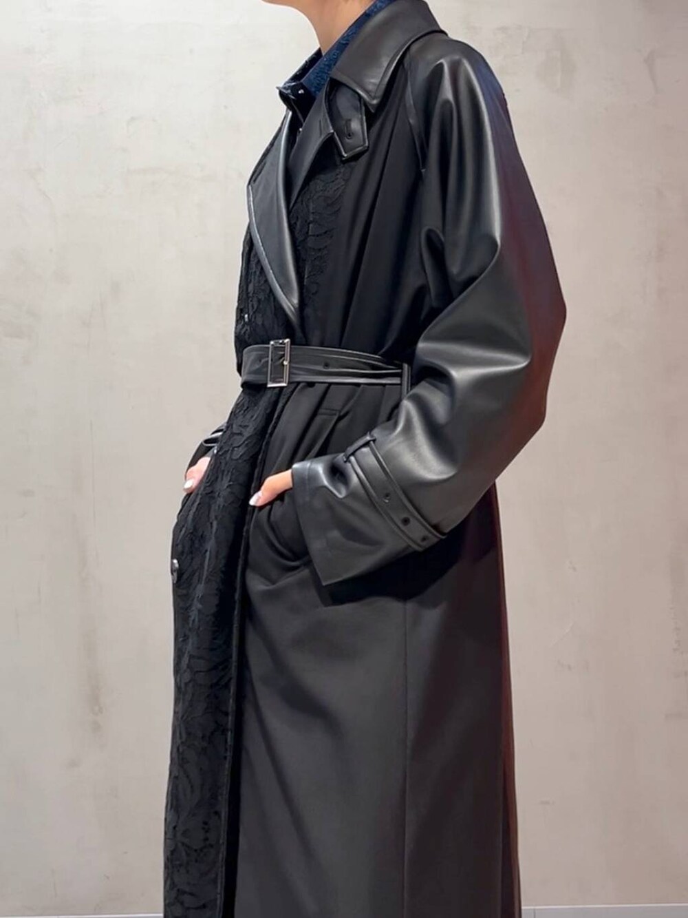 ブラック系のスカート、ブルー系のシャツ/ブラウス、ブラック系のトレンチコートを着用したレディースの秋コーディネートの2枚目の写真