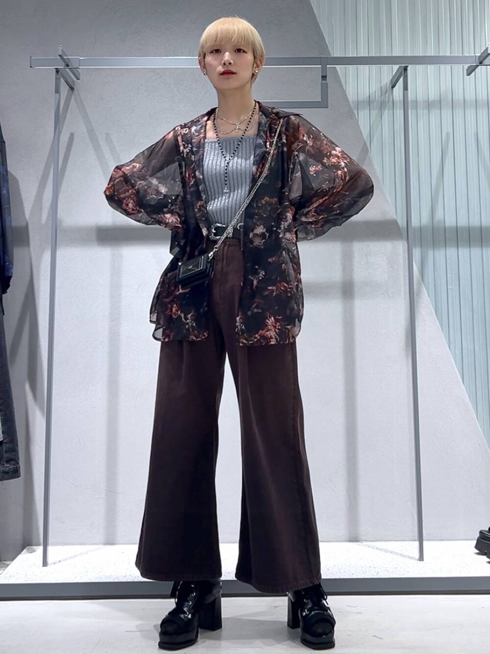 グレー系のタンクトップ、ブラック系のブーツ、オレンジ系のシャツ/ブラウスを着用したレディースの春コーディネートの6枚目の写真