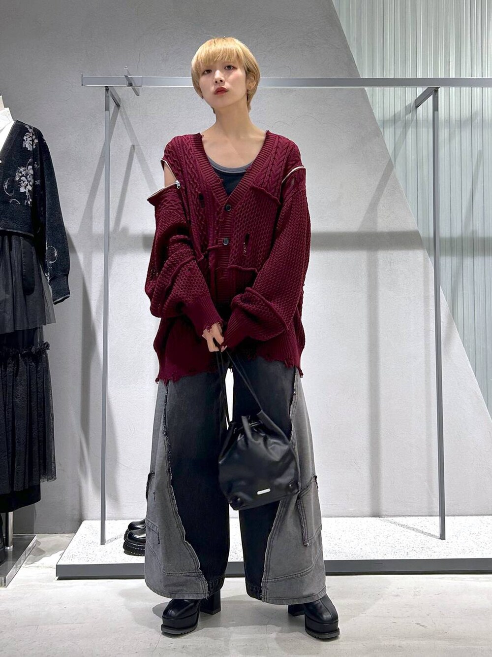 ブラック系のショルダーバッグ、ブラック系のデニムパンツ、ブルー系のタンクトップを着用したレディースの秋コーディネートの6枚目の写真