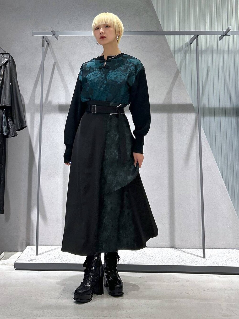 ブラック系のブルゾン、ブラック系のブーツ、グリーン系のスウェットを着用したレディースの秋コーディネートの3枚目の写真