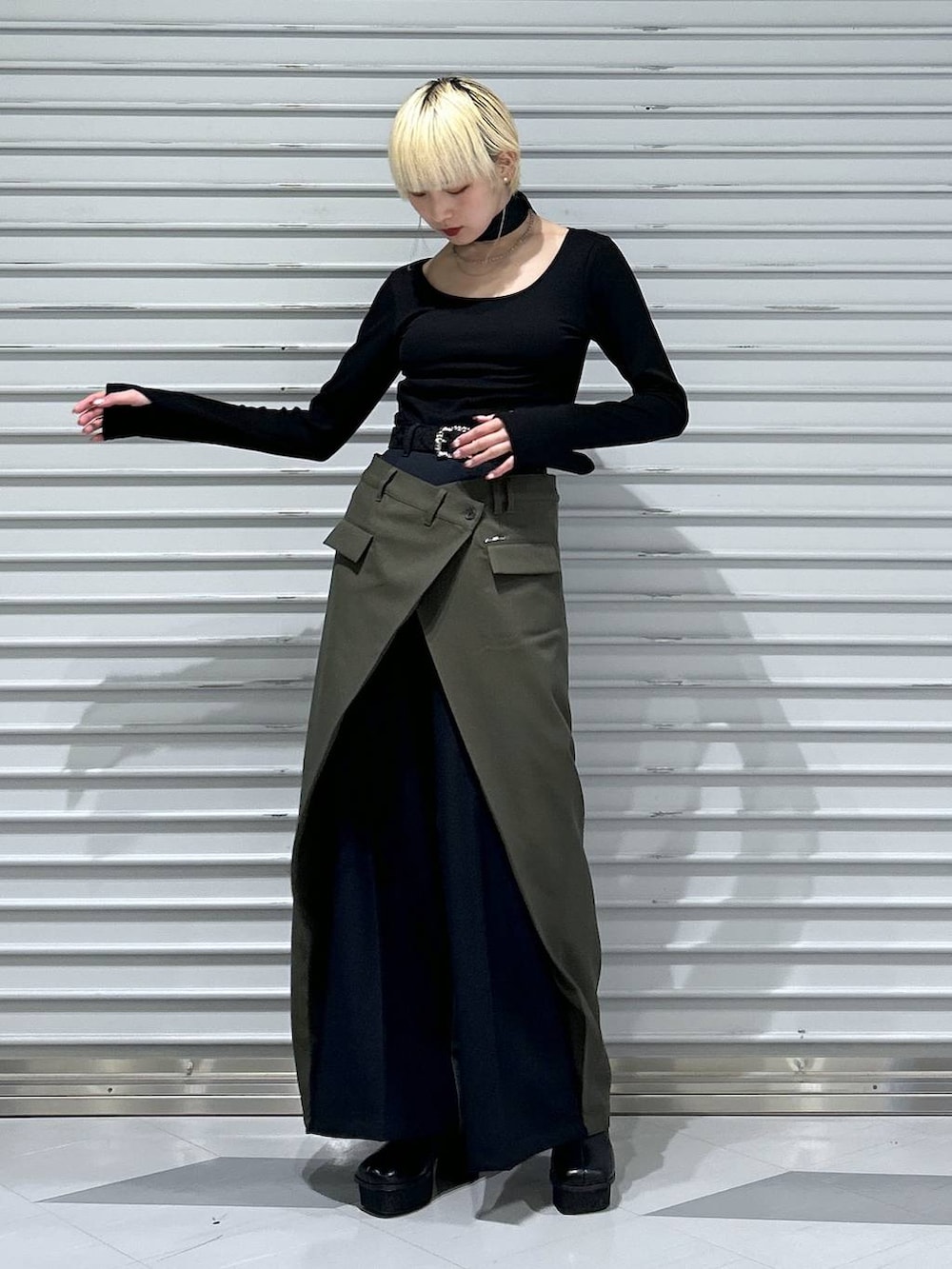 グレー系のブーツ、グレー系のカーディガン/ボレロ、グリーン系のスラックスを着用したレディースの冬コーディネートの2枚目の写真