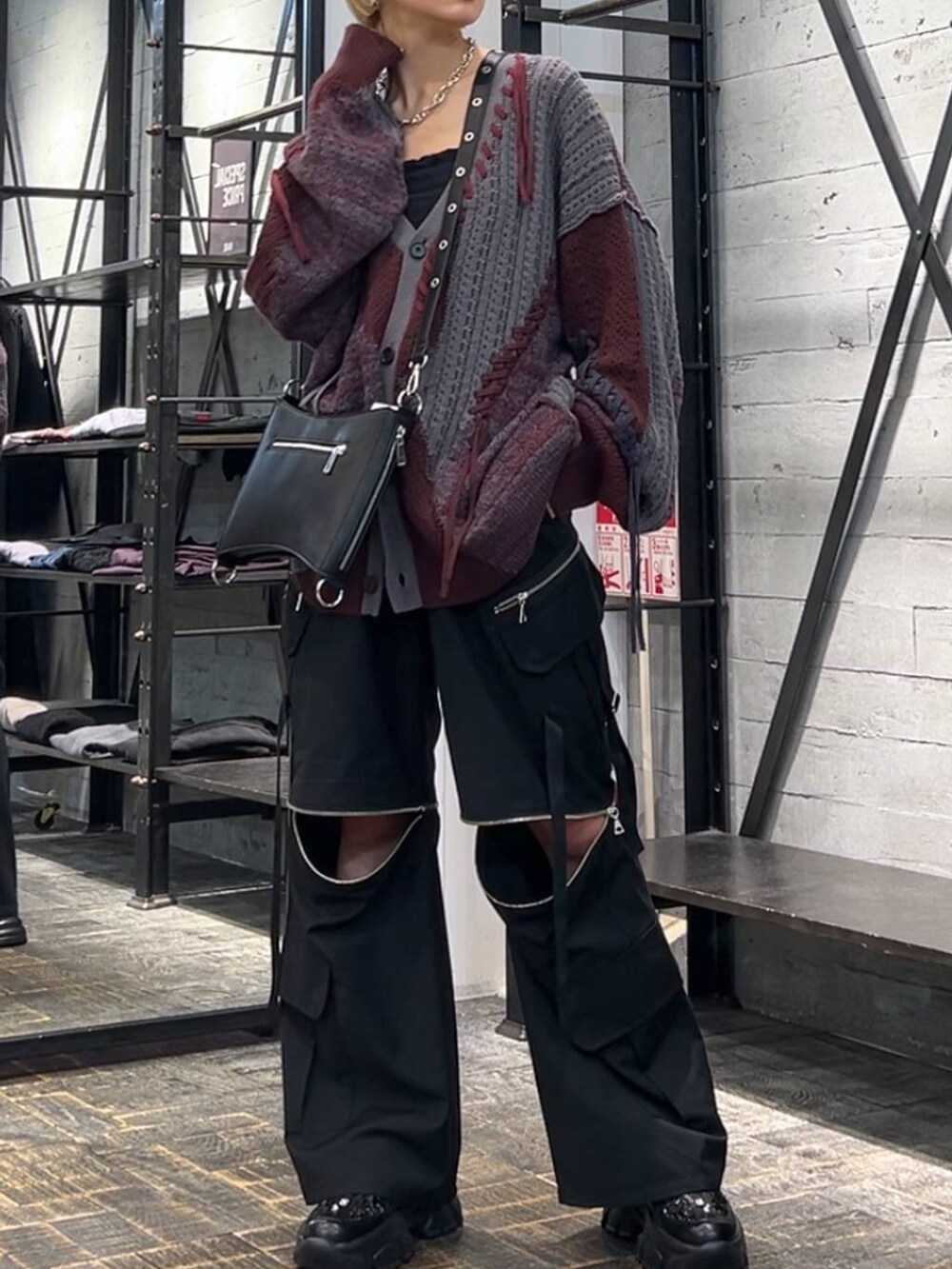 レッド系のカーディガン/ボレロ、ブラック系のカーゴパンツ、ブラック系のスニーカーを着用したレディースの秋コーディネートの4枚目の写真