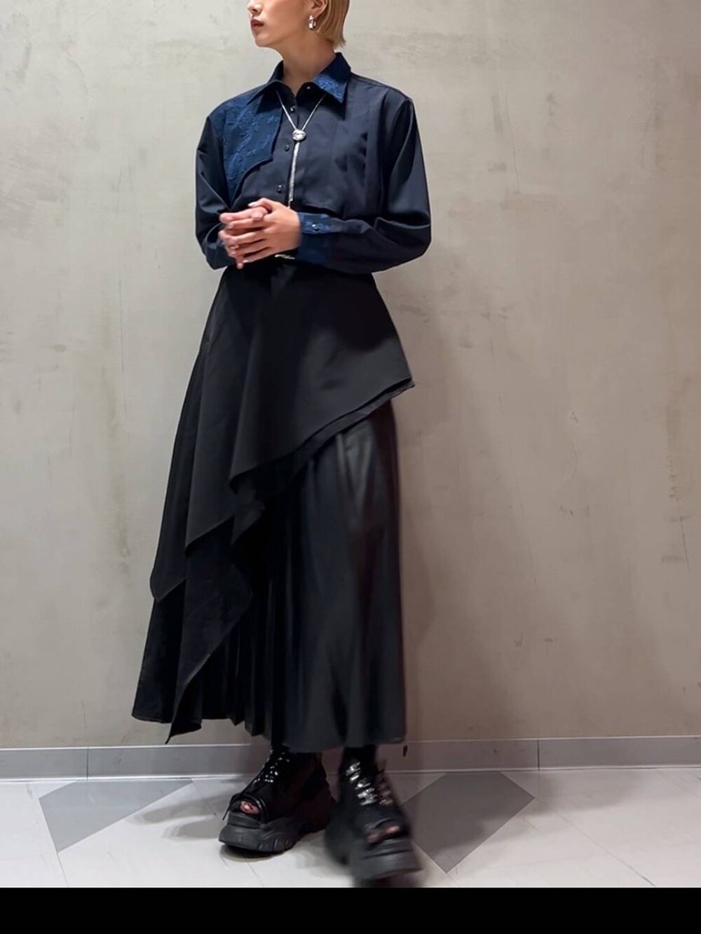 ブラック系のスカート、ブルー系のシャツ/ブラウス、シルバー系のネックレスを着用したレディースの秋コーディネートの3枚目の写真