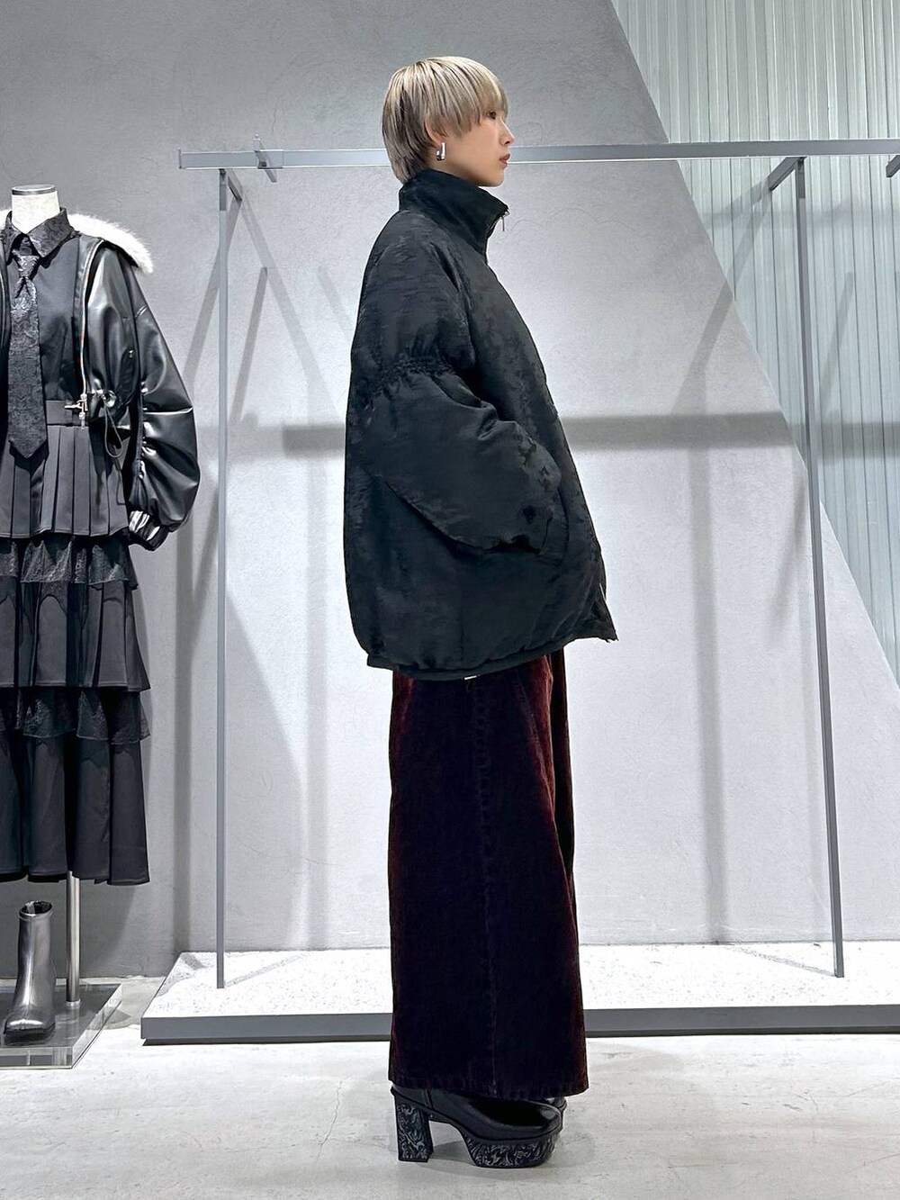 グレー系のブーツ、ブラック系のニット/セーター、レッド系のデニムパンツを着用したレディースの冬コーディネートの3枚目の写真