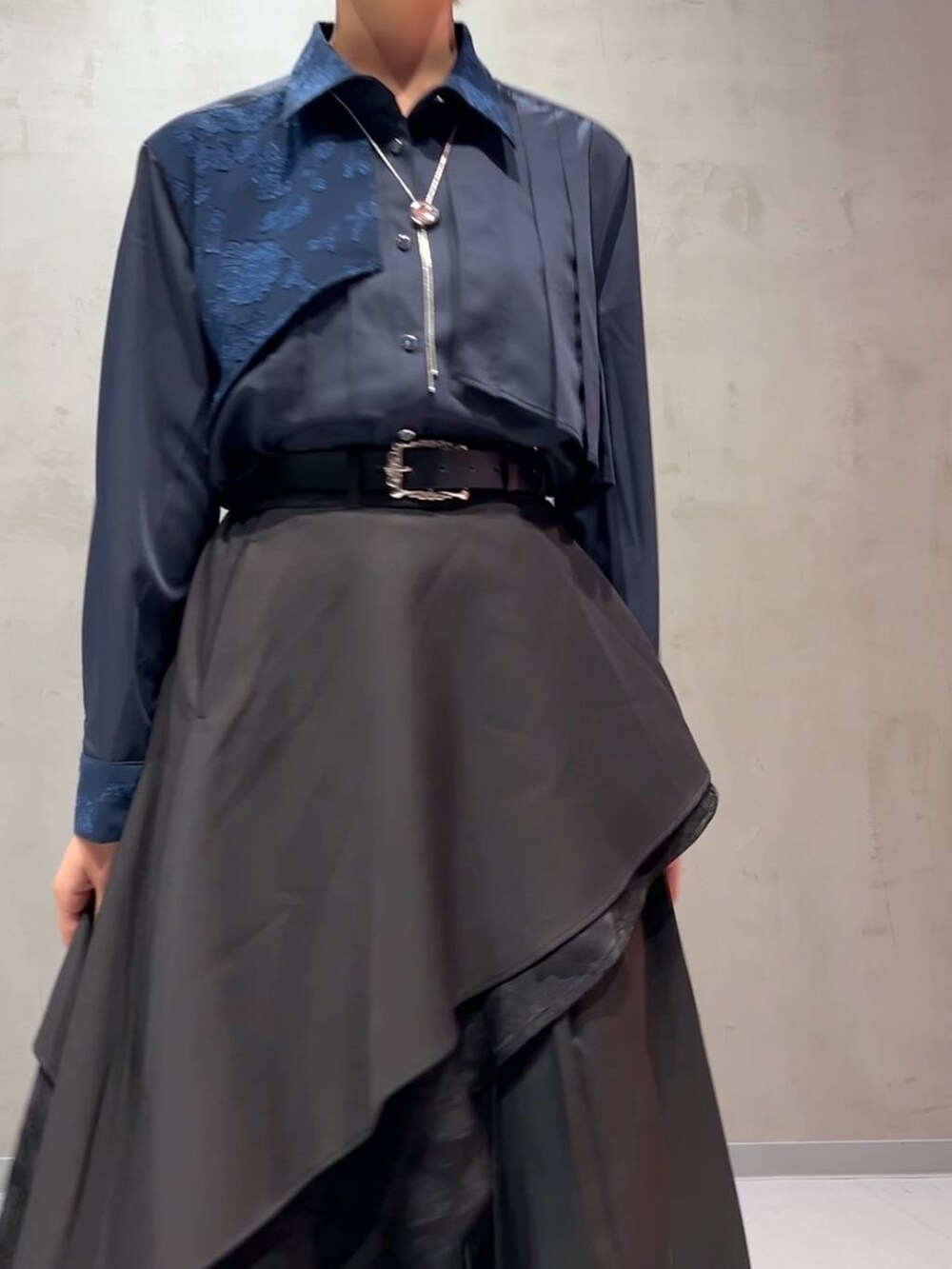 ブラック系のスカート、ブルー系のシャツ/ブラウス、シルバー系のネックレスを着用したレディースの秋コーディネートの4枚目の写真