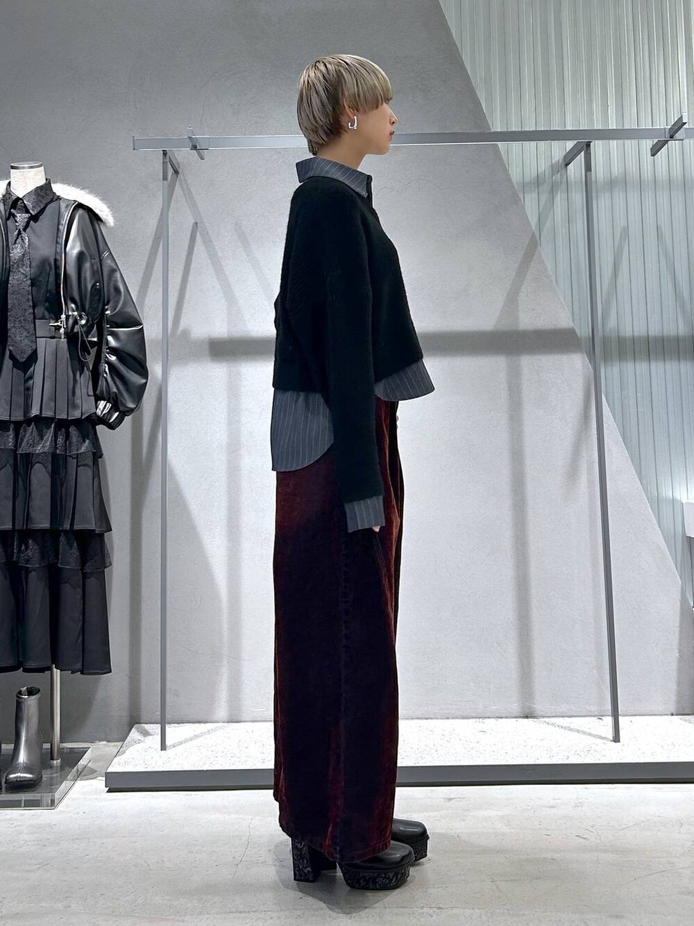 グレー系のブーツ、ブラック系のニット/セーター、レッド系のデニムパンツを着用したレディースの冬コーディネートの5枚目の写真