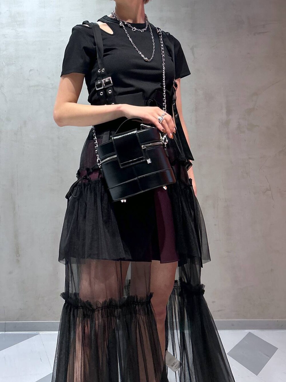 レッド系のスカート、グレー系のサンダル、パープル系のその他パンツを着用したレディースの夏コーディネートの3枚目の写真