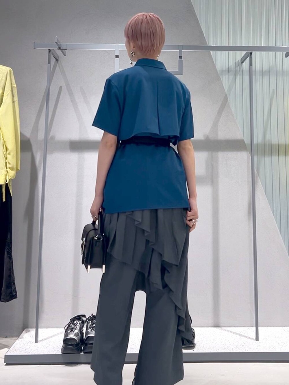 ブラック系のショルダーバッグ、ブラック系のブーツ、ブルー系のシャツ/ブラウスを着用したレディースの春コーディネートの4枚目の写真