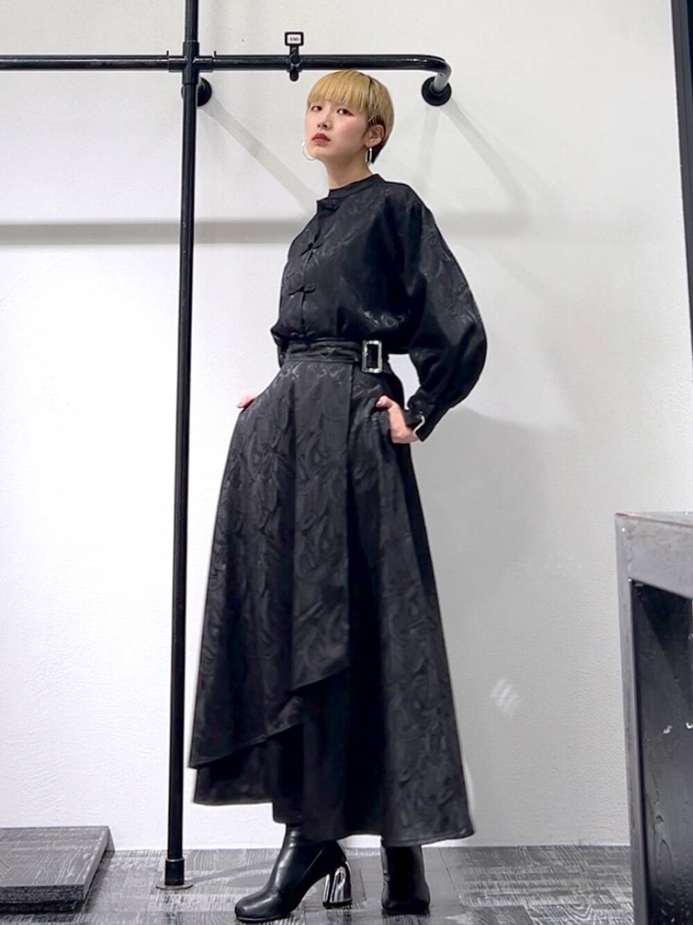 ブラック系のスカート、ブラック系のブーツ、ブラック系のシャツ/ブラウスを着用したレディースの春コーディネートの2枚目の写真