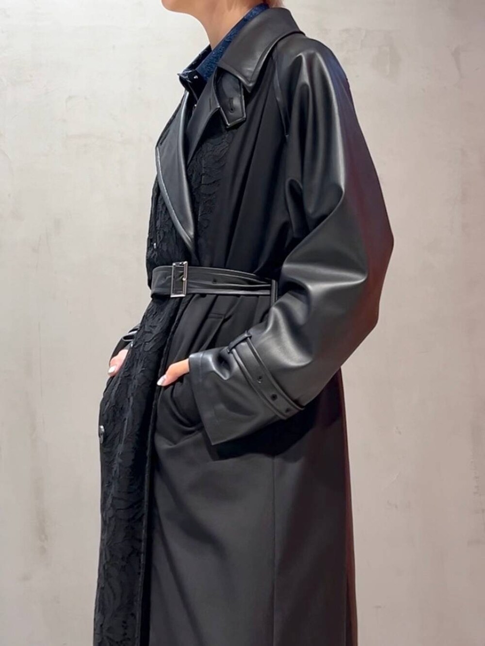 ブラック系のスカート、ブルー系のシャツ/ブラウス、ブラック系のトレンチコートを着用したレディースの秋コーディネートの5枚目の写真