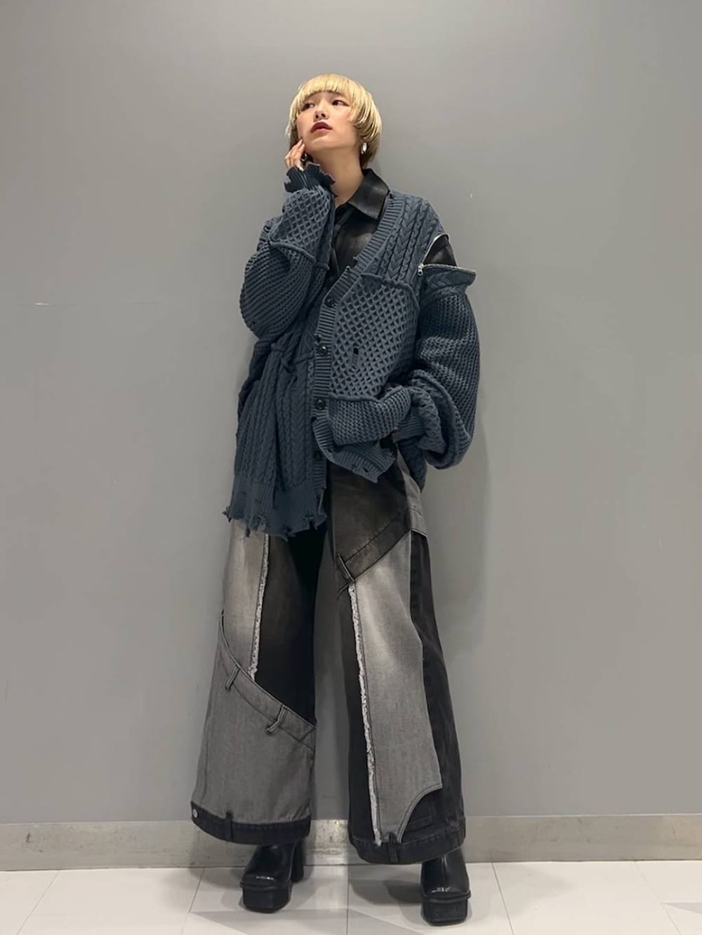 ブラック系のデニムパンツ、ブルー系のカーディガン/ボレロ、ブラック系のブーツを着用したレディースの秋コーディネートの8枚目の写真