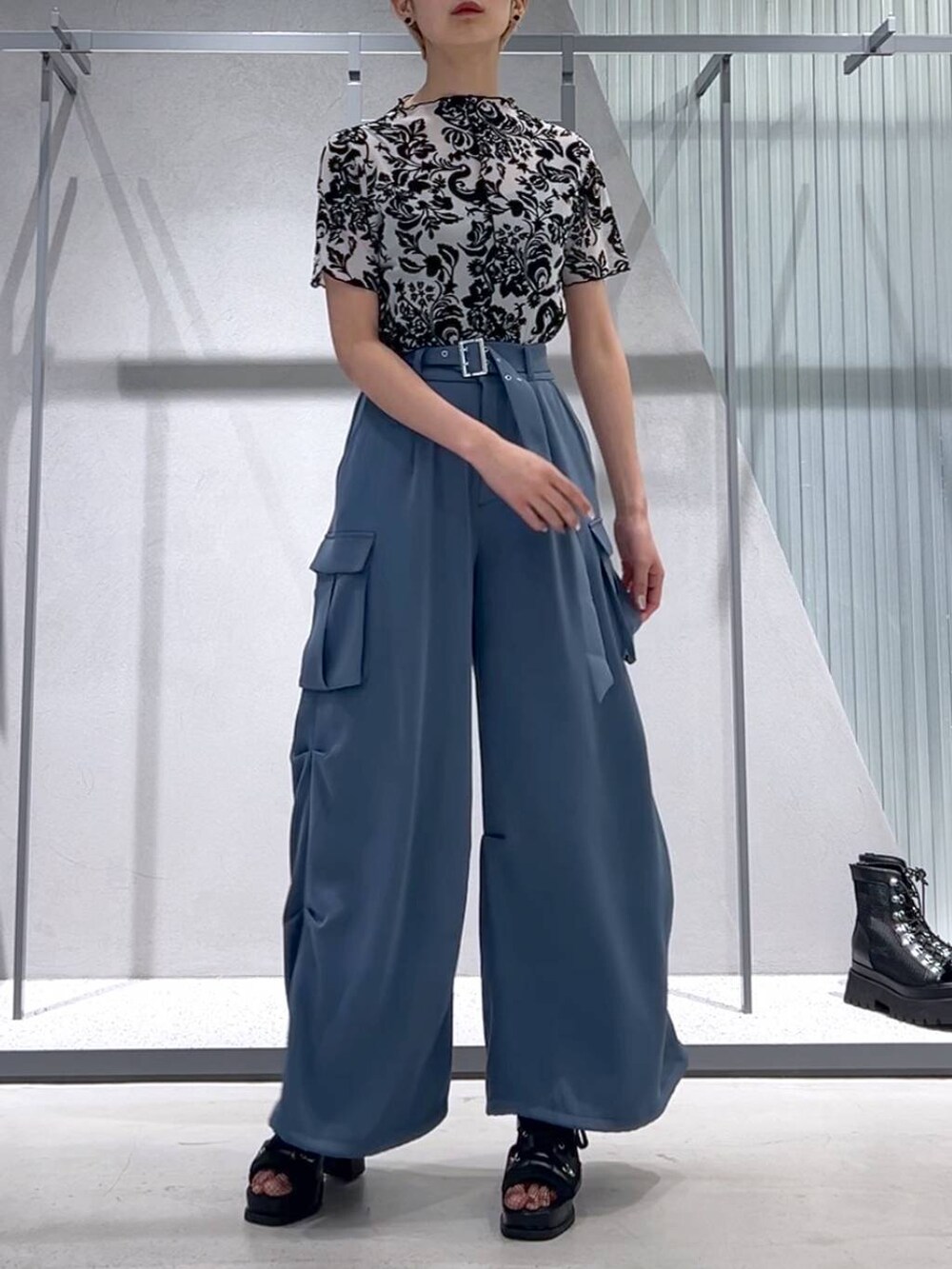 ブルー系のカーゴパンツ、ブラック系のブーツ、ホワイト系のテーラードジャケットを着用したレディースの春コーディネートの4枚目の写真