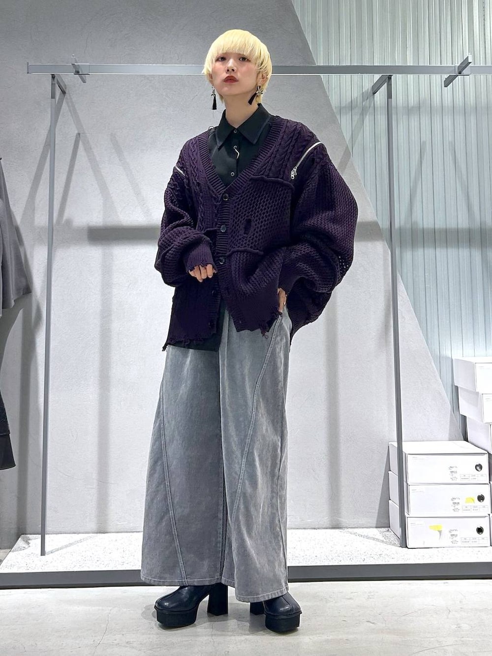 グレー系のブーツ、パープル系のカーディガン/ボレロ、グレー系のデニムパンツを着用したレディースの秋コーディネートの2枚目の写真