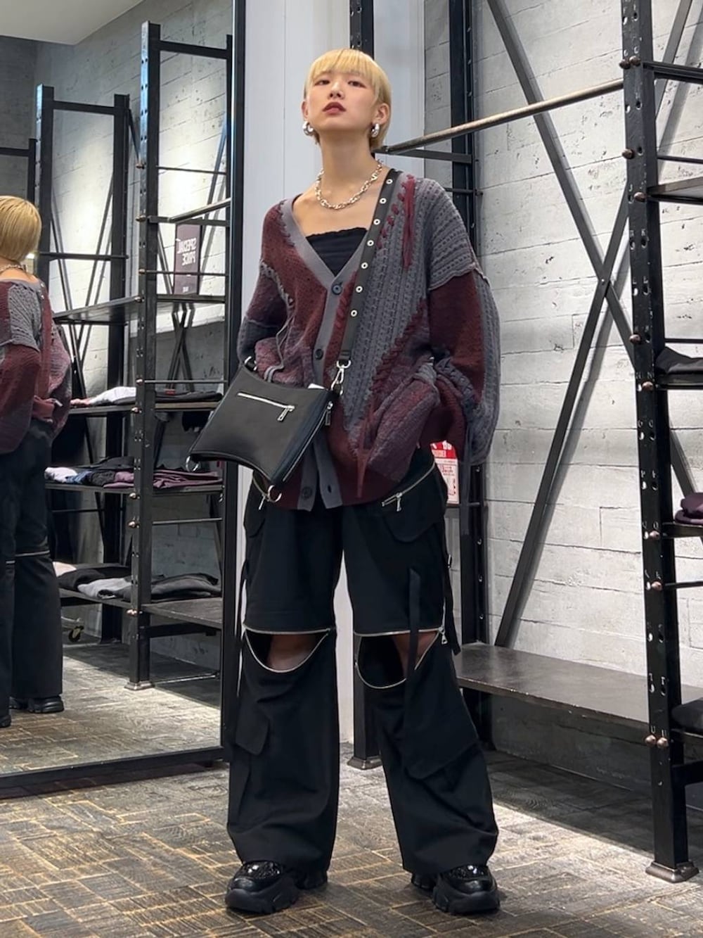 レッド系のカーディガン/ボレロ、ブラック系のカーゴパンツ、ブラック系のスニーカーを着用したレディースの秋コーディネートの3枚目の写真