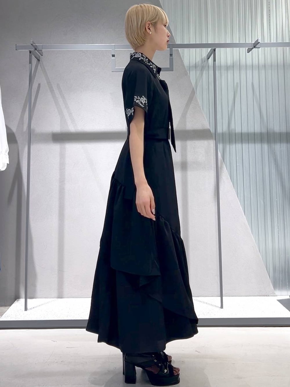 ブラック系のネクタイ、ブラック系のブーツ、ブラック系のスカートを着用したレディースの春コーディネートの3枚目の写真