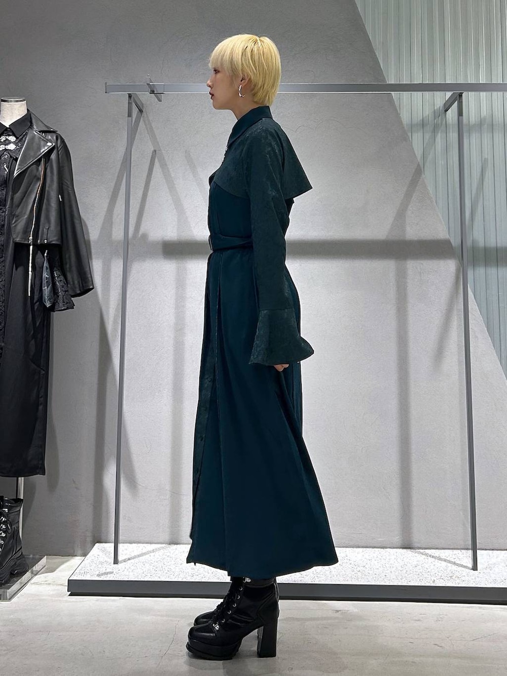 ブラック系のブーツ、グリーン系のワンピースを着用したレディースの秋コーディネートの4枚目の写真