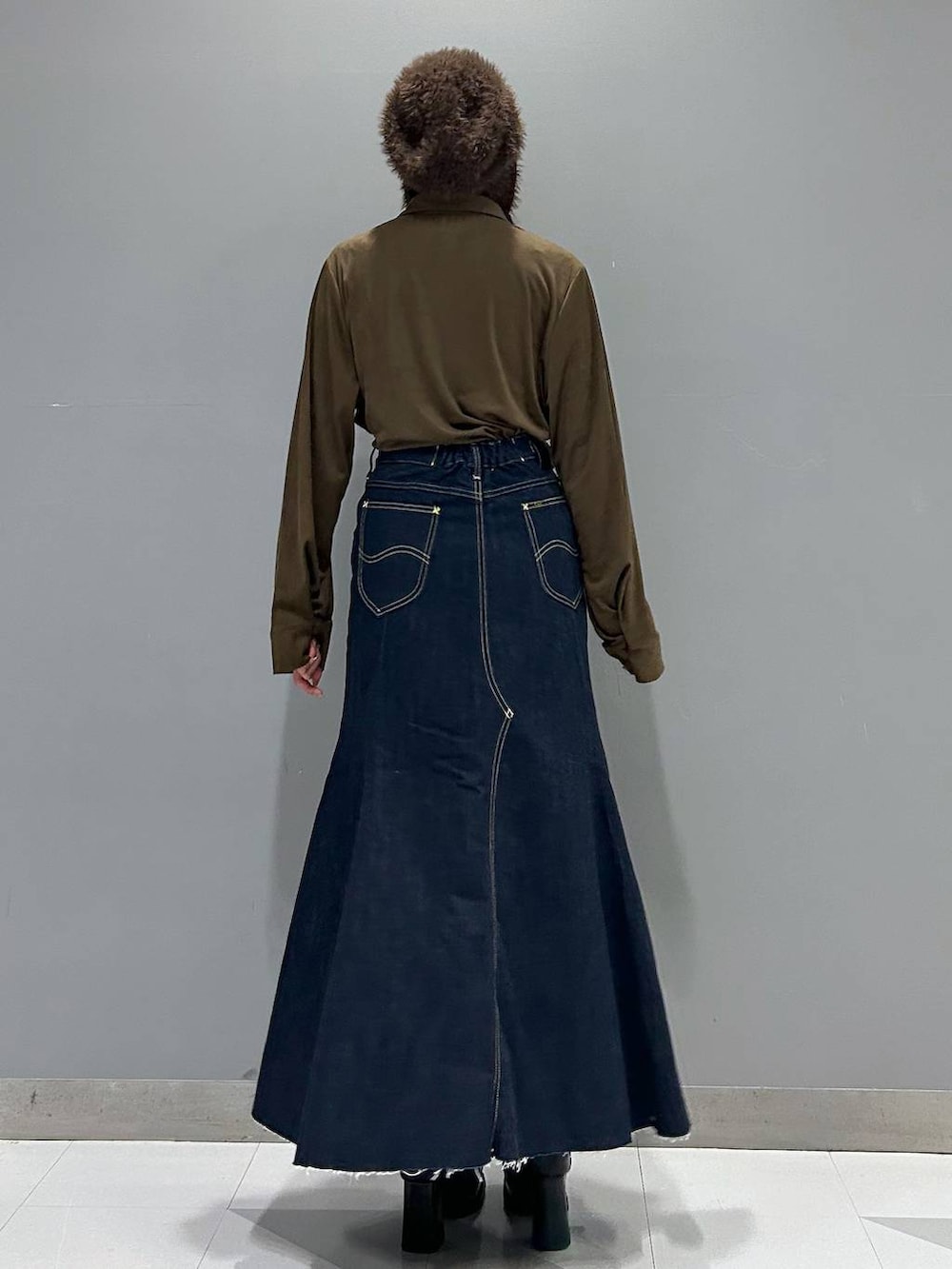 ブルー系のデニムスカート、ブラック系のブーツ、ブラウン系のシャツ/ブラウスを着用したレディースの秋コーディネートの3枚目の写真