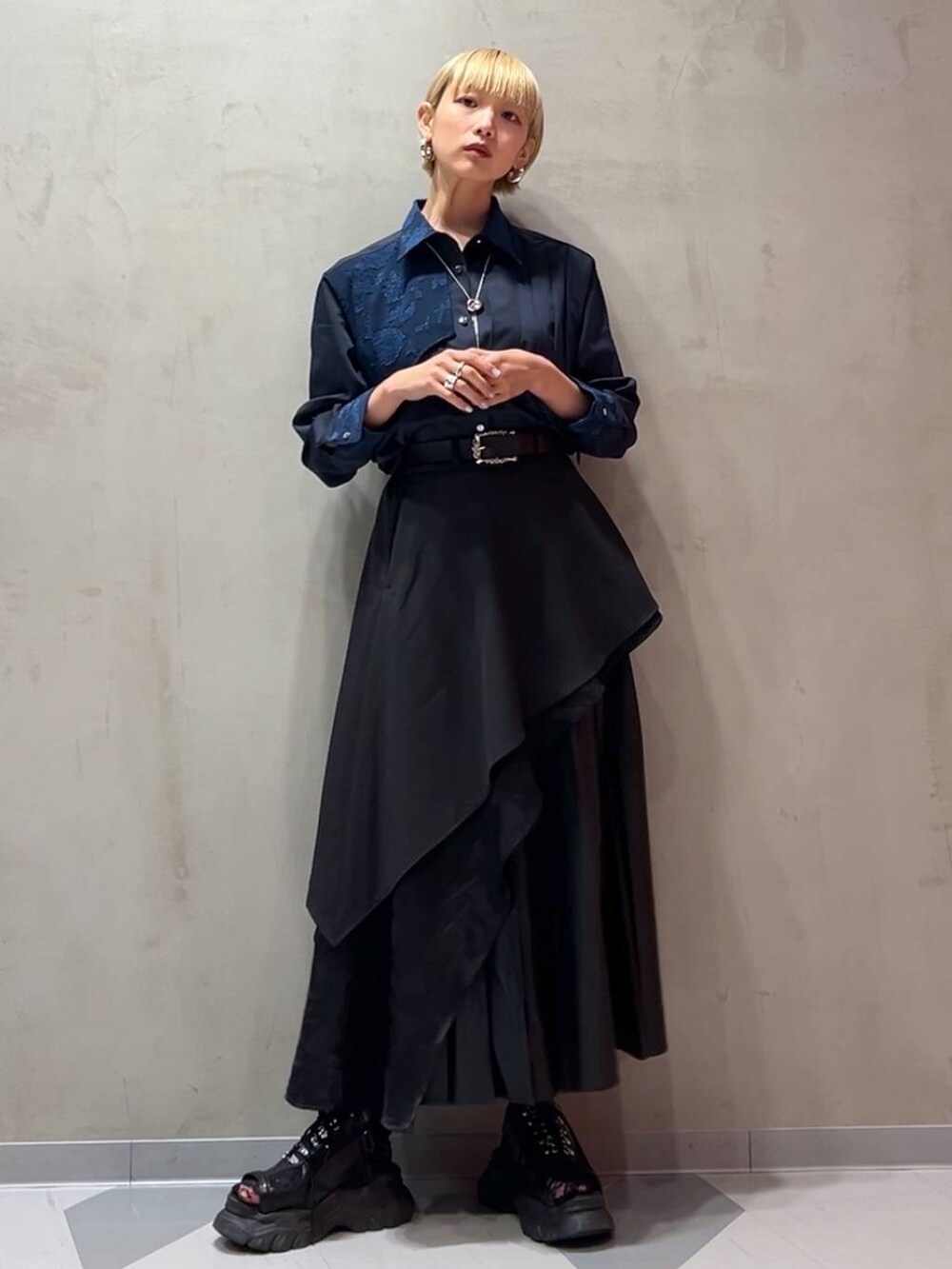 ブラック系のスカート、ブルー系のシャツ/ブラウス、ブラック系のトレンチコートを着用したレディースの秋コーディネートの7枚目の写真