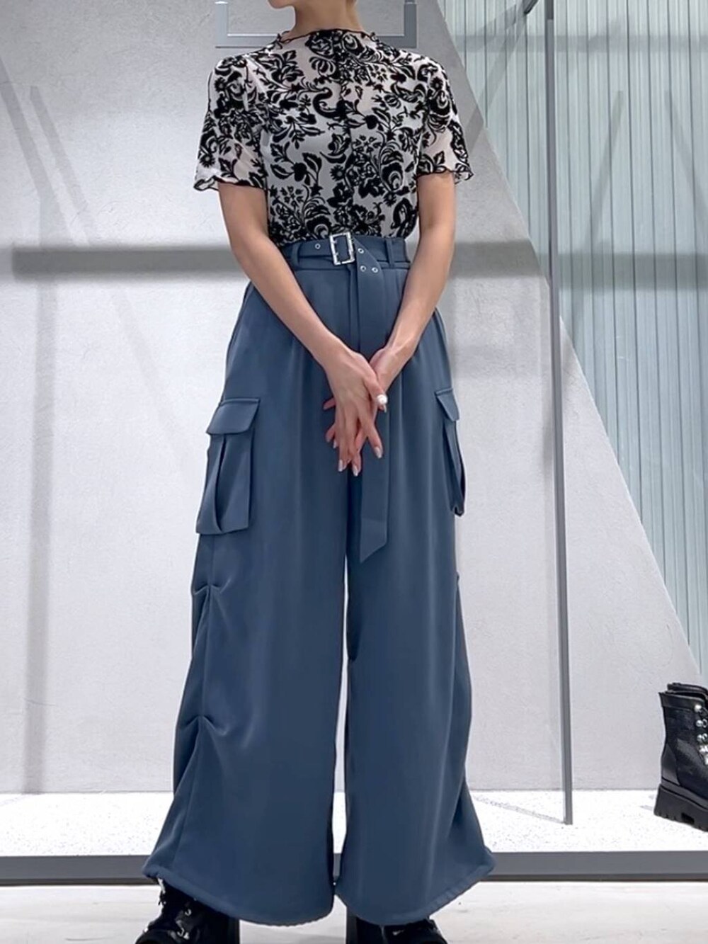 ブルー系のカーゴパンツ、ブラック系のブーツ、ホワイト系のテーラードジャケットを着用したレディースの春コーディネートの6枚目の写真