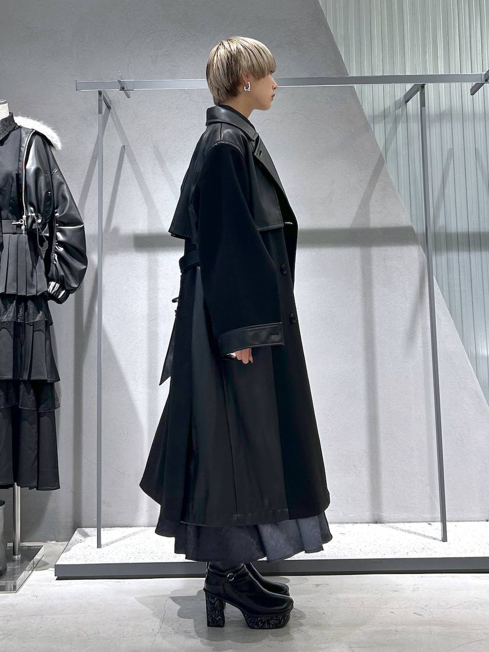 ブラック系のチェスターコート、グレー系のブーツ、ブラック系のシャツ/ブラウスを着用したレディースの冬コーディネートの4枚目の写真