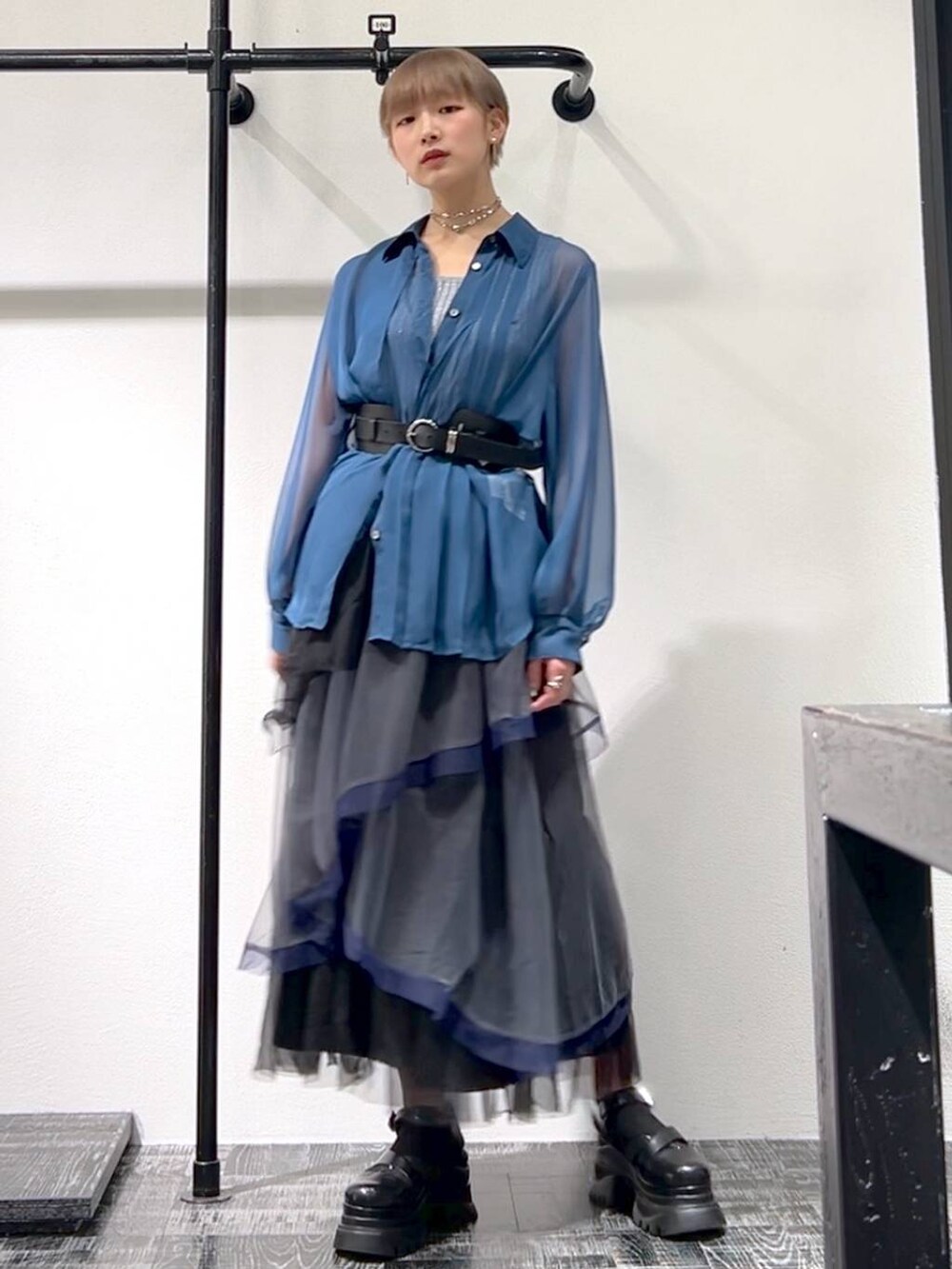 ブルー系のシャツ/ブラウス、グレー系のスカート、ブラック系のサンダルを着用したレディースの春コーディネートの2枚目の写真