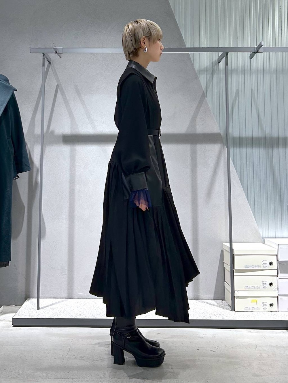 ブラック系のチェスターコート、パープル系のTシャツ/カットソー、グレー系のブーツを着用したレディースの冬コーディネートの5枚目の写真