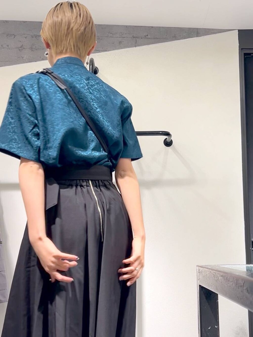 ホワイト系のサンダル、ブラック系のショルダーバッグ、ブラック系のスカートを着用したレディースの春コーディネートの2枚目の写真