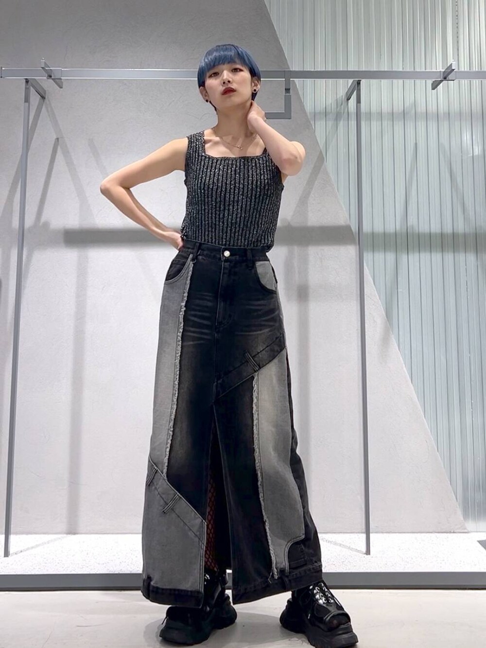 ブラック系のタンクトップ、ブラック系のサンダル、ブラック系のデニムスカートを着用したレディースの春コーディネートの5枚目の写真