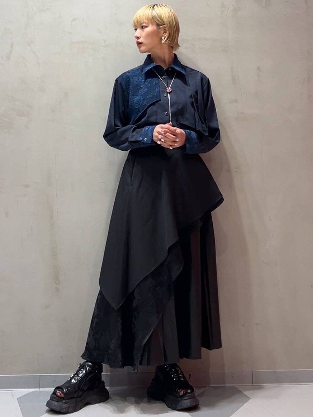 ブラック系のスカート、ブルー系のシャツ/ブラウス、ブラック系のトレンチコートを着用したレディースの秋コーディネートの8枚目の写真