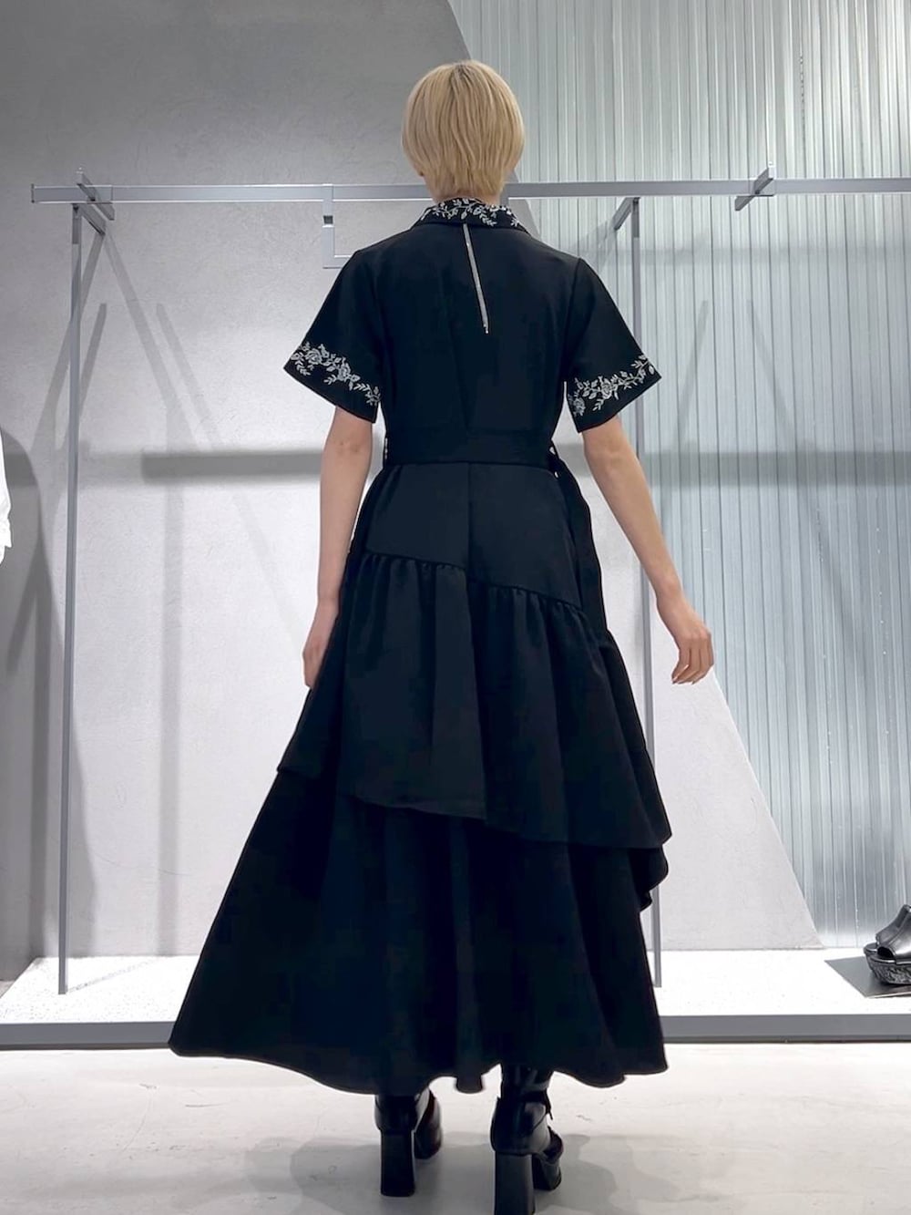 ブラック系のネクタイ、ブラック系のブーツ、ブラック系のスカートを着用したレディースの春コーディネートの4枚目の写真