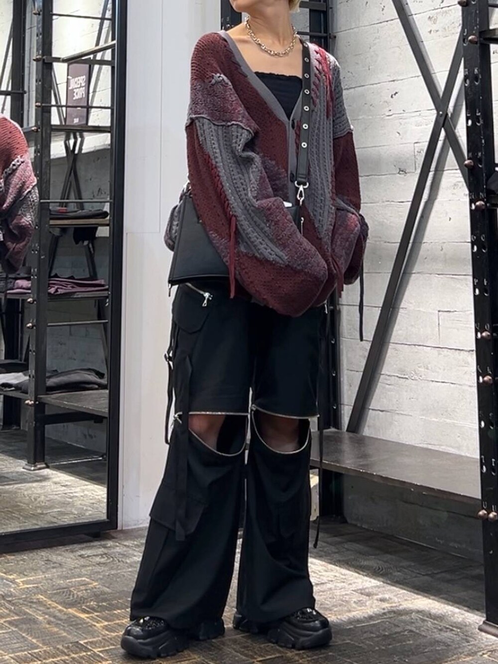 レッド系のカーディガン/ボレロ、ブラック系のカーゴパンツ、ブラック系のスニーカーを着用したレディースの秋コーディネートの2枚目の写真