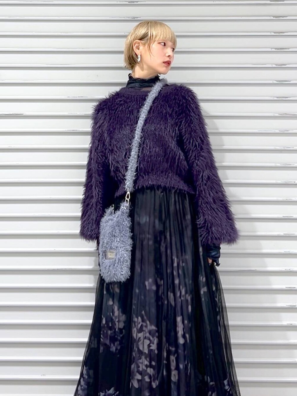 パープル系のニット/セーター、ブラック系のブーツ、グレー系のショルダーバッグを着用したレディースの秋コーディネートの3枚目の写真