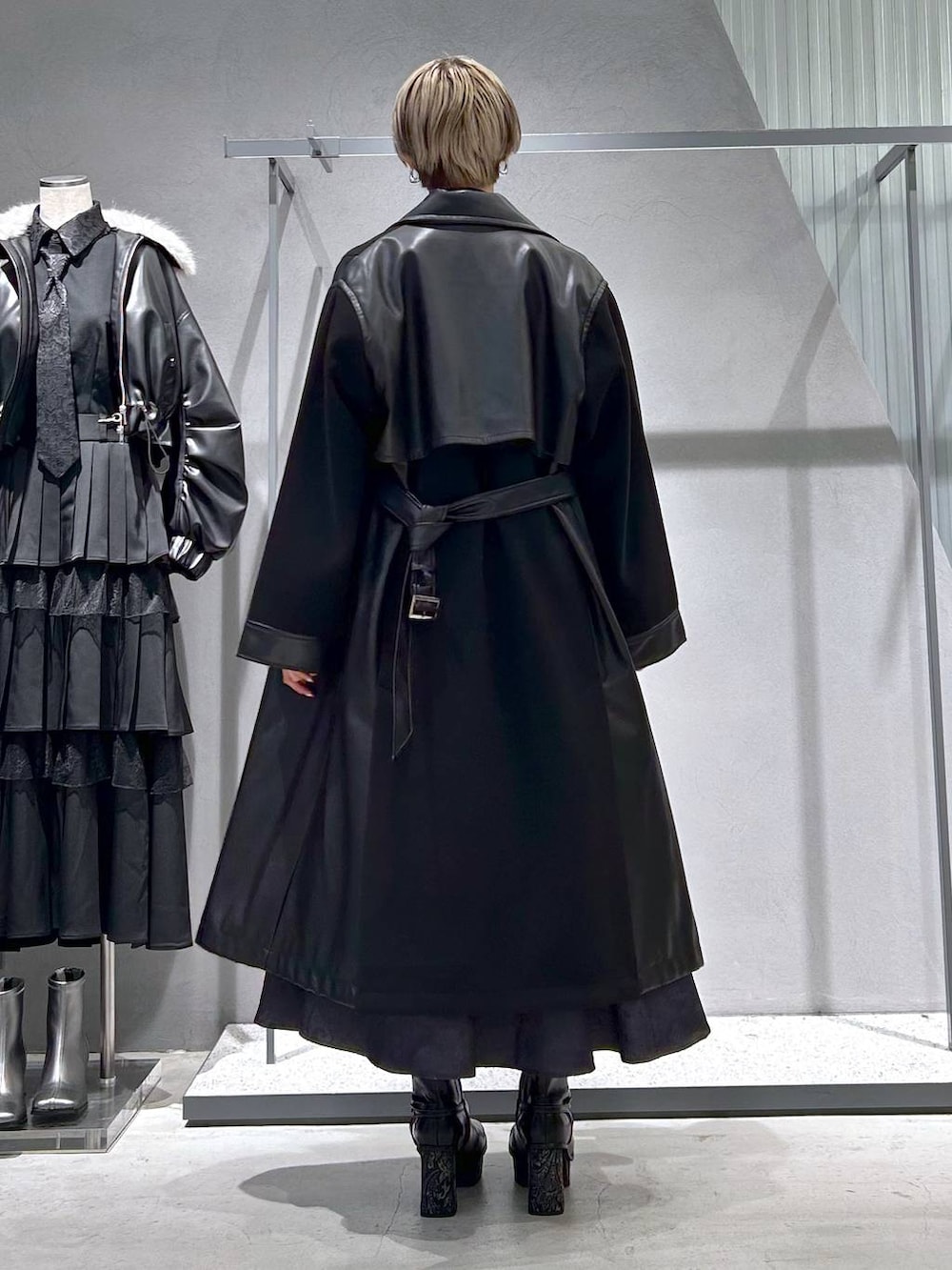 ブラック系のチェスターコート、グレー系のブーツ、ブラック系のシャツ/ブラウスを着用したレディースの冬コーディネートの5枚目の写真