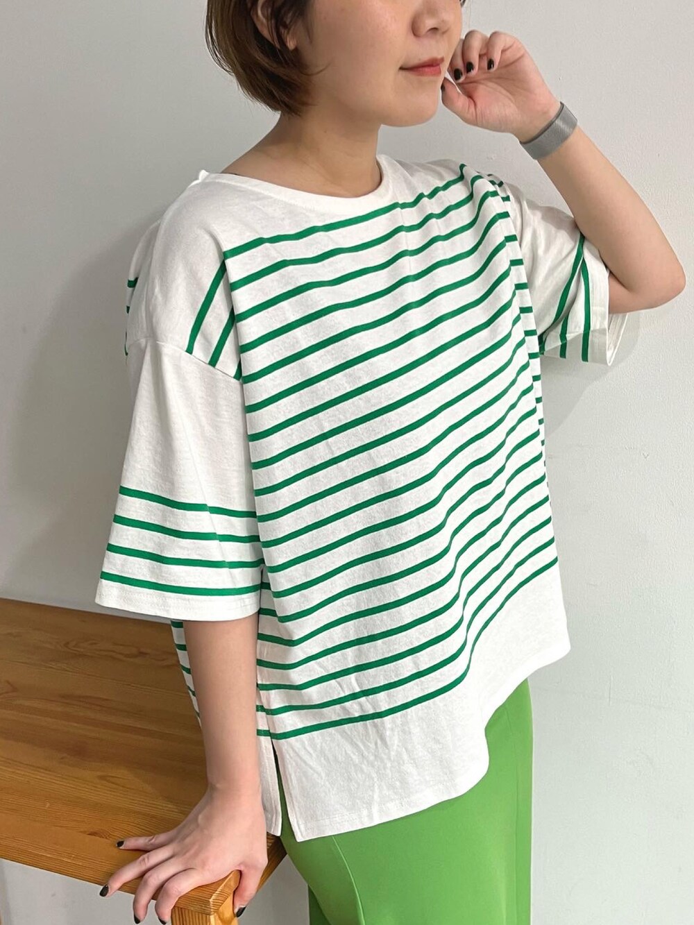 グリーン系のTシャツ/カットソー、グリーン系のスカート、ブラック系のサンダルを着用したレディースの夏コーディネートの2枚目の写真