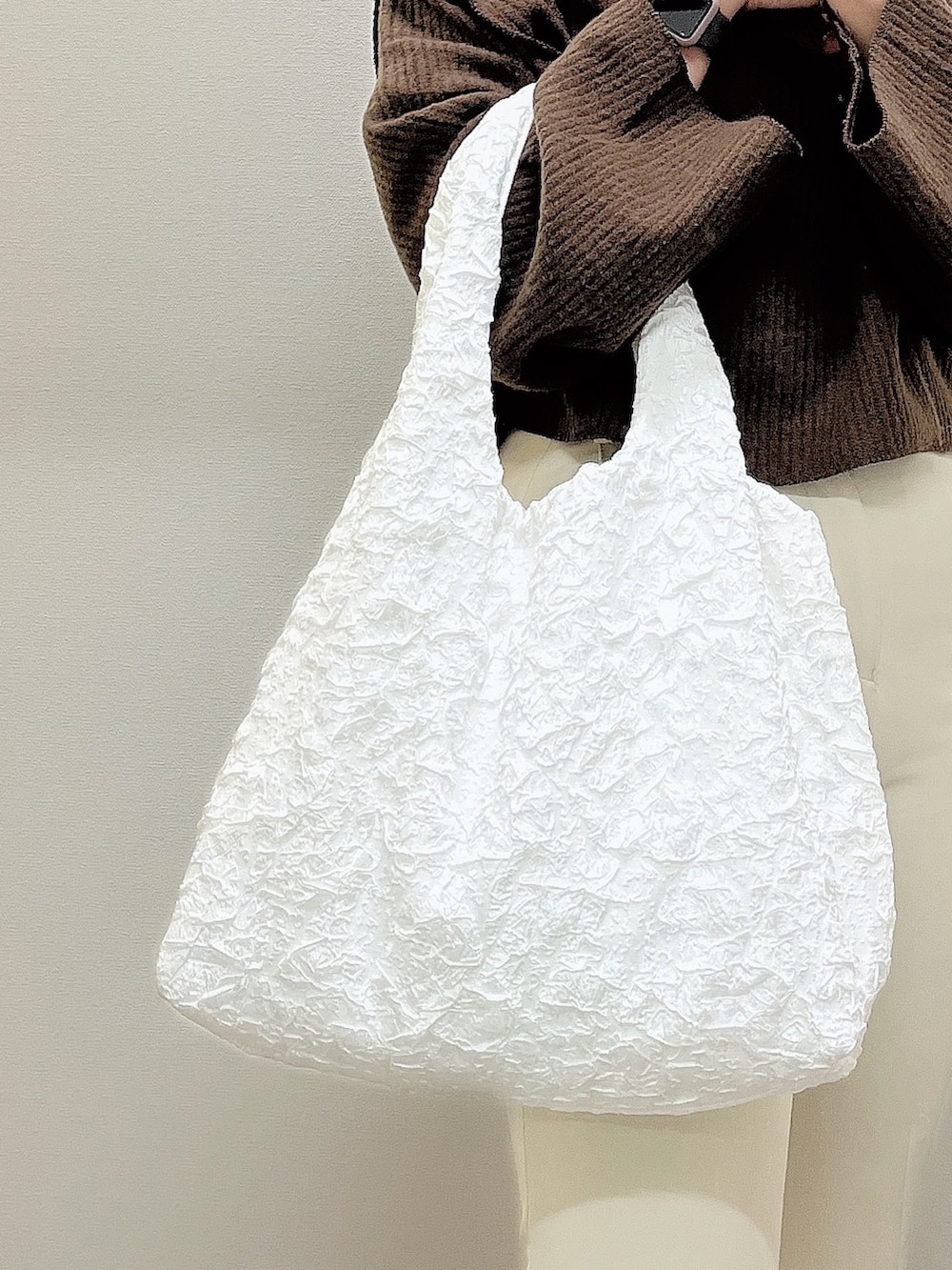 ブラウン系のニット/セーター、ホワイト系のその他パンツ、ホワイト系のブーツを着用したレディースの冬コーディネートの2枚目の写真