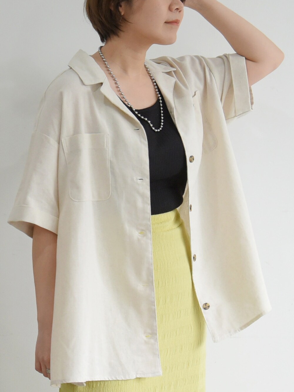 ブラック系のサンダル、グリーン系のスカート、ベージュ系のシャツ/ブラウスを着用したレディースの夏コーディネートの2枚目の写真